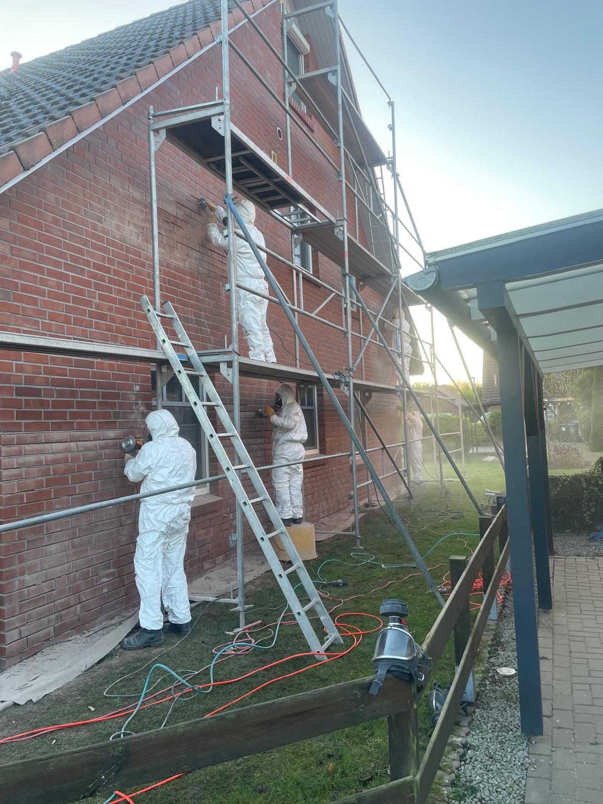 Team beim Sandstrahlen und Reinigen einer Hausfassade